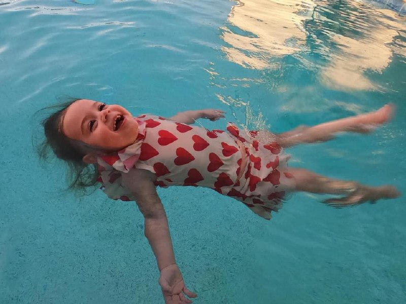 Baby floating safely in a heart swimsuit